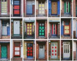 Each door of the building has a different color an Each door of the building has a different color and design. Also, the galleries of the apartment are painted sky blue and it looks like the person can